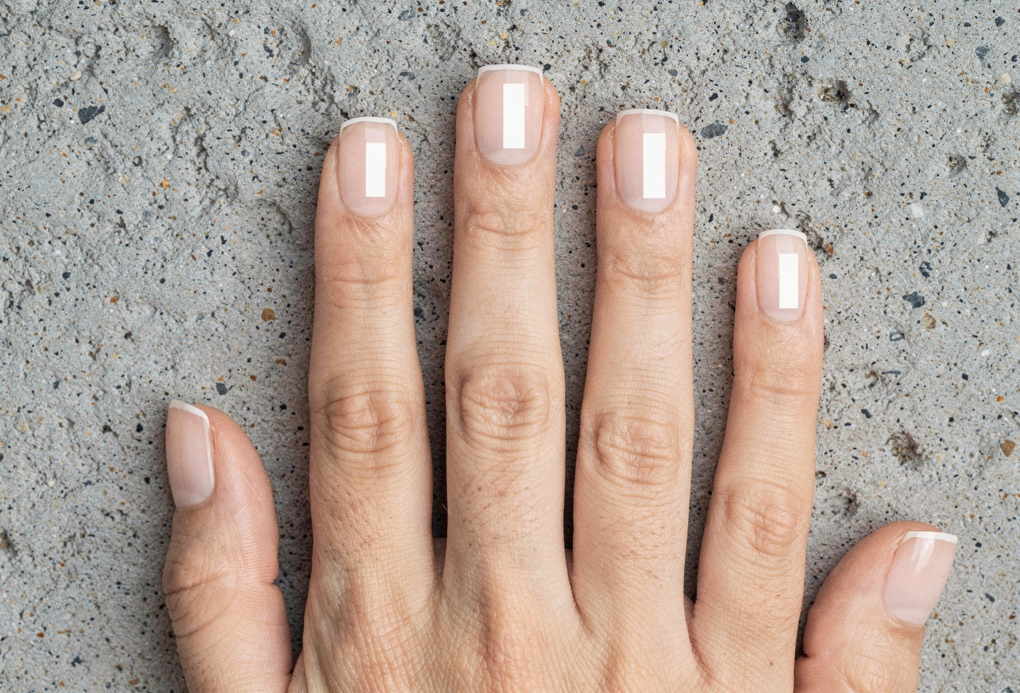 Cam efektli şeffaf jel kaplama her tırnak yüzeyinde softbox yansıması tekstürlü beton üzerine