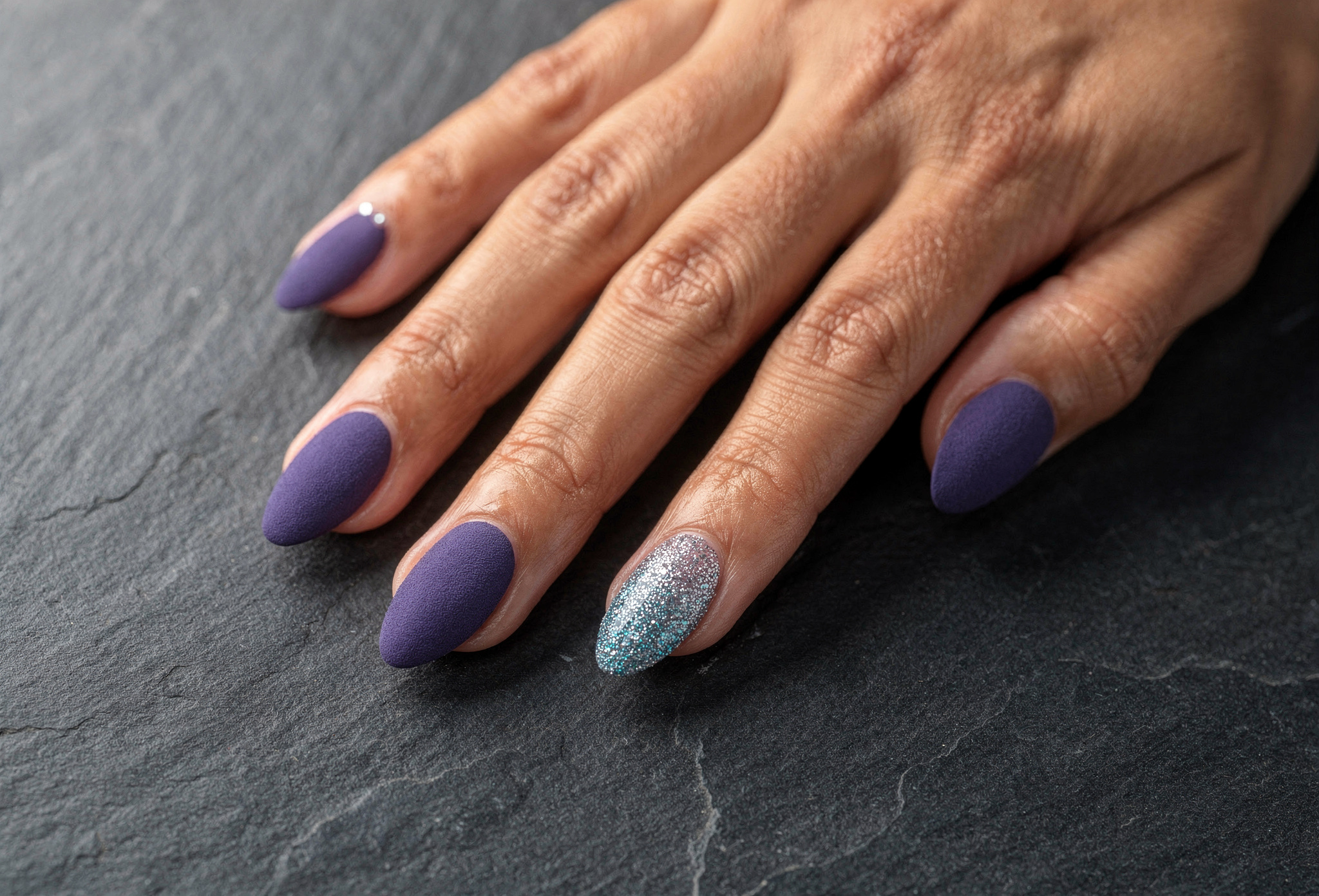 Kadifemsi mat periwinkle jel tırnaklar koyu arduvaz yüzeyde parlak gümüş aksan tırnak